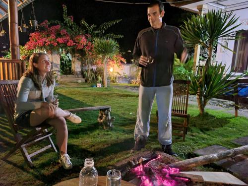 a man standing next to a woman sitting next to a fire at Batur lake view in Kintamani