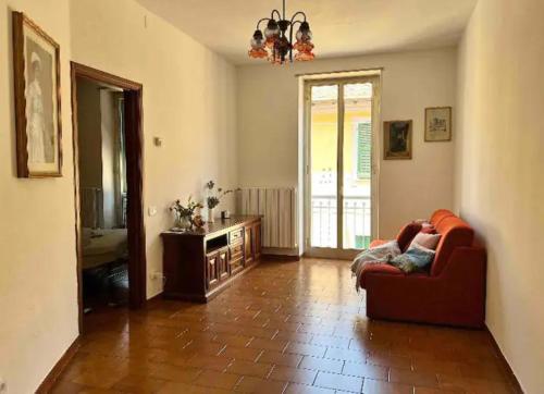 een woonkamer met een rode stoel en een bank bij Cheerful Room, Sharing kitchen in a Cosy Family Art House, Ideal for one person or couple in Sanremo