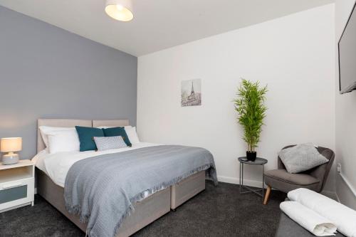 a white bedroom with a bed and a chair at Amazing House with Central Location in Darlington