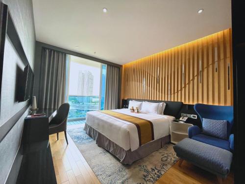 um quarto de hotel com uma cama e uma cadeira em Fraser Place Puteri Harbour em Nusajaya