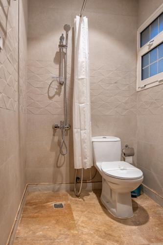 a bathroom with a toilet and a shower at فندق كارم in Raḩīmah