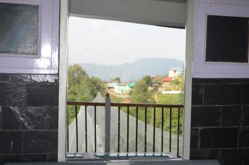 a window of a house with a view of a mountain at Hari Om Paradise in Kūfrī
