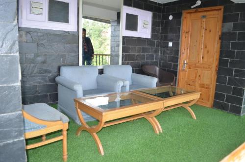 a living room with a couch and a coffee table at Hari Om Paradise in Kūfrī