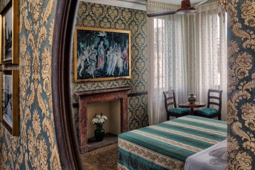 a bedroom with a bed and a painting on the wall at Hotel Galleria in Venice