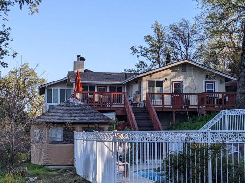 a house with a white fence in front of it at A Bed of Roses in Oakhurst