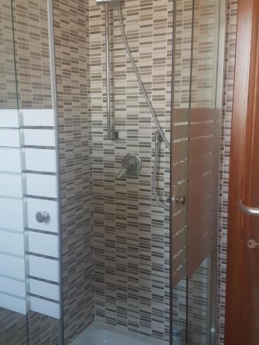 a shower with a glass door in a bathroom at CASE ORCHIDEA - ROSA BLU in La Caletta