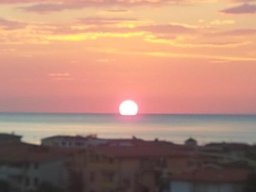 a sunset over the ocean with the sun in the horizon at CASE ORCHIDEA - ROSA BLU in La Caletta