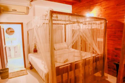 a bedroom with a canopy bed in a room at Coral Beach Hotel in Mirissa