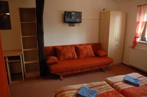 a living room with a couch and a tv on the wall at Privát Nováč in Nové Město nad Metují