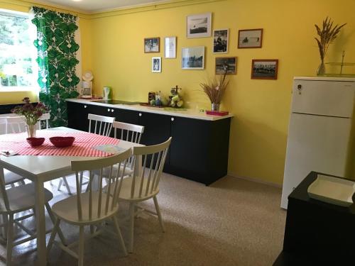 a kitchen with a table and a white refrigerator at Torgu Royal Guesthouse in Iide