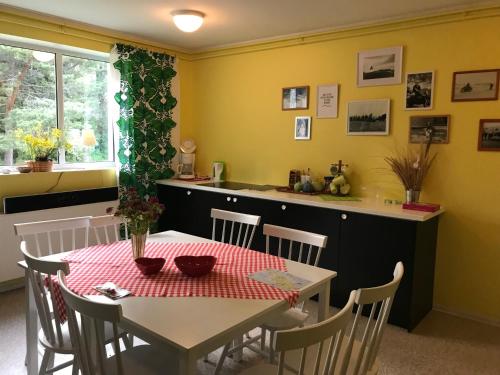 a dining room with a table and a kitchen at Torgu Royal Guesthouse in Iide