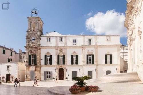 a large building with a clock tower in a courtyard at Corsomessapia121 in Martina Franca