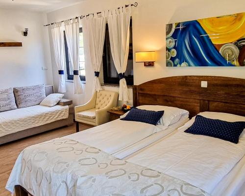 a hotel room with two beds and a couch at Green Garden Plitvice lakes in Plitvica selo