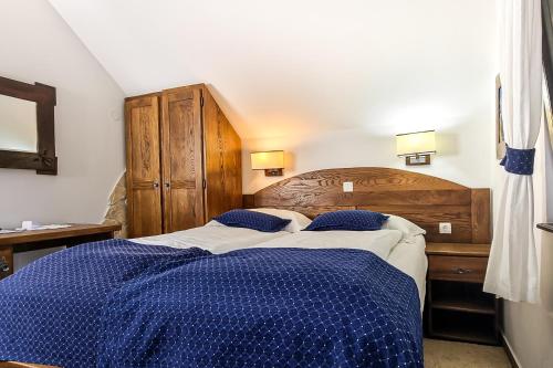 a bedroom with two beds with blue and white sheets at Green Garden Plitvice lakes in Plitvica selo
