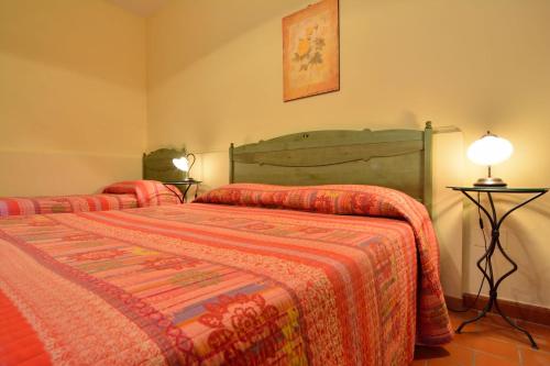 a bedroom with two beds and a lamp on a table at Agriturismo La Dimora dei Cavalieri in Vaglio di Basilicata
