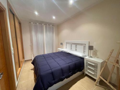 ein Schlafzimmer mit einem blauen Bett, einer Kommode und einem Fenster in der Unterkunft Vera Pueblo Salinas in Vera