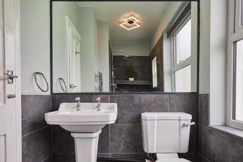 a bathroom with a sink and a toilet and a mirror at Ground Floor at the Old Vicarage in Scarborough