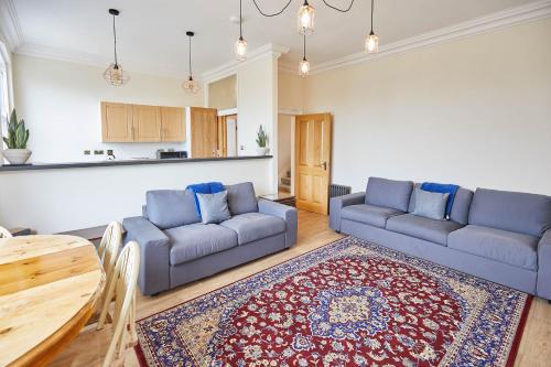 a living room with two couches and a table at Ground Floor at the Old Vicarage in Scarborough