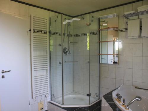 a bathroom with a shower and a tub and a sink at Kanino in Monschau