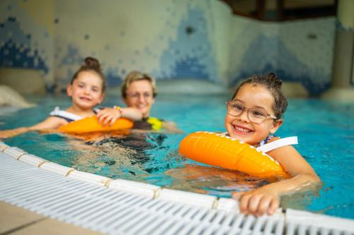 two children in a swimming pool with inflatables at Familien- Sportresort BRENNSEEHOF in Feld am See