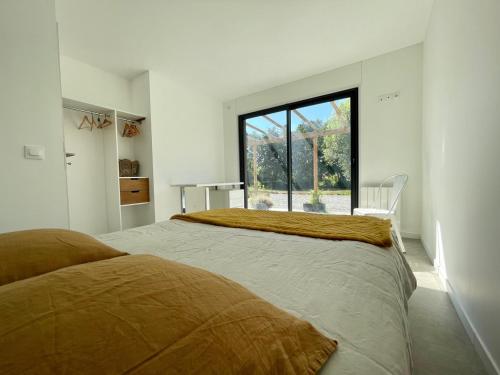 a bedroom with a large bed with a large window at Gîtes du Moulin à Tan à Saché 37 in Saché