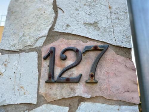 ein Metallschild an der Seite einer Steinmauer in der Unterkunft Bounganville 127 in Alcamo Marina