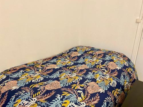 - un lit avec une couverture bleue et orange dans l'établissement L'essentiel, Studio Rouen proche gare - 053, à Rouen