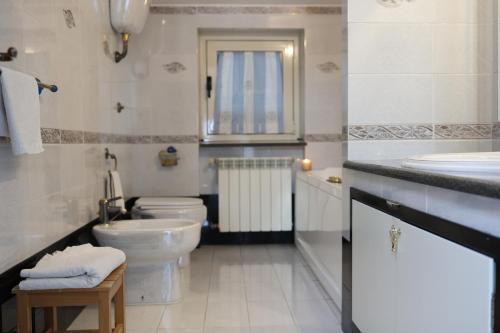 a white bathroom with a toilet and a sink at B&B Privileged in Pollena Trocchia