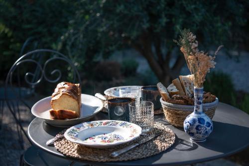un tavolo con un piatto di torta e cestini di pane di Maison Sumiane a Brignoles