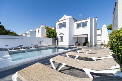 Villa con piscina y tumbonas en Chalet Árbol de la Vida, en Chiclana de la Frontera