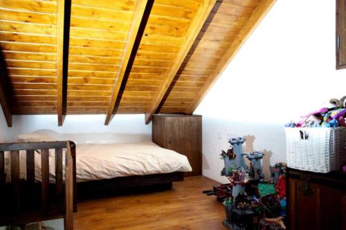um quarto com uma cama e um tecto em madeira em El vergel encantado em La Ñora