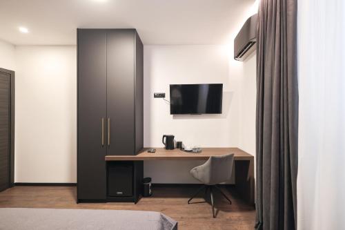 a room with a desk and a tv on a wall at City Premium Rooms Old town in Zadar