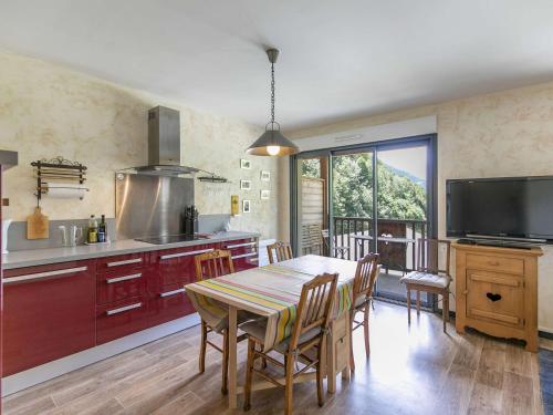 une cuisine avec une table et des chaises ainsi qu'une télévision dans l'établissement Bel appartement 4 pers, terrasse, parking privé, proche ski et thermes - FR-1-403-98, à Barèges