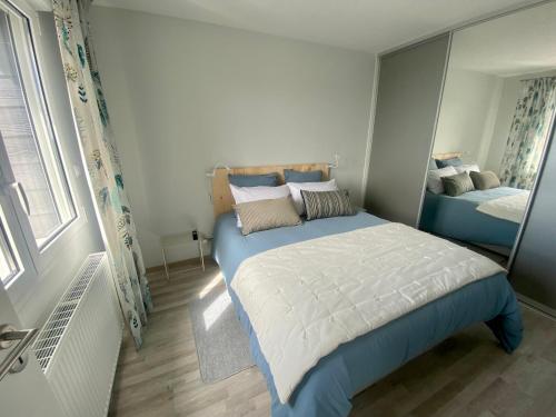 a small bedroom with a bed and a mirror at Appartement de standing VUE MER in Berck-sur-Mer