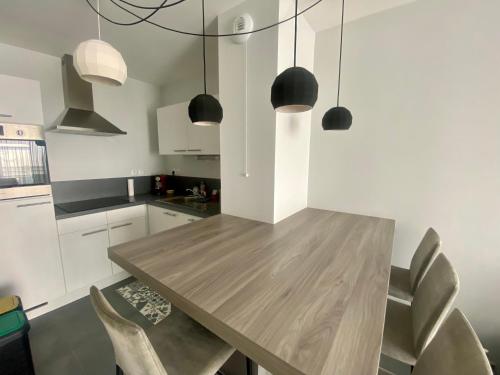 - une cuisine avec une table et des chaises en bois dans l'établissement Appartement de standing VUE MER, à Berck-sur-Mer