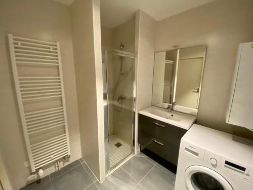 a bathroom with a shower sink and a washing machine at Appartement de standing VUE MER in Berck-sur-Mer