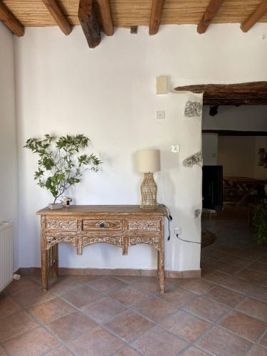 a wooden table with a lamp on a wall at Stone built country house in Louvaras Village in Louvaras