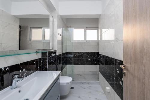 a bathroom with a tub and a toilet and a sink at Viviane Paulos Villa in Gennadi