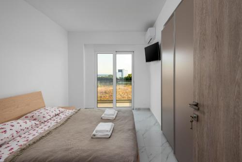 a bedroom with a bed with two towels on it at Viviane Paulos Villa in Gennadi