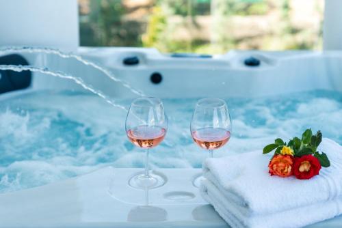 two glasses of wine and towels on a table at Viviane Paulos Villa in Gennadi