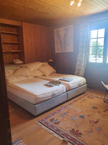 a bedroom with a bed and a window and a rug at Chalet Charme Ovronnaz in Ovronnaz
