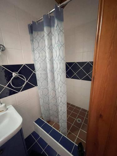 a bathroom with a shower with blue and white tiles at Stone built country house in Louvaras Village in Louvaras