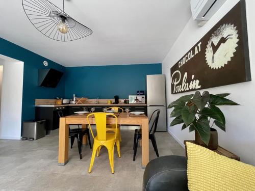 a dining room with a table and yellow chairs at Gîtes du Moulin à Tan à Saché 37 in Saché