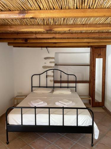a bed in a room with a wooden ceiling at Stone built country house in Louvaras Village in Louvaras