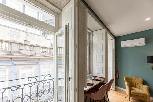 Pokój z balkonem ze stołem i krzesłami w obiekcie Turquoise Central Flat w AC & Balcony by LovelyStay w Porto