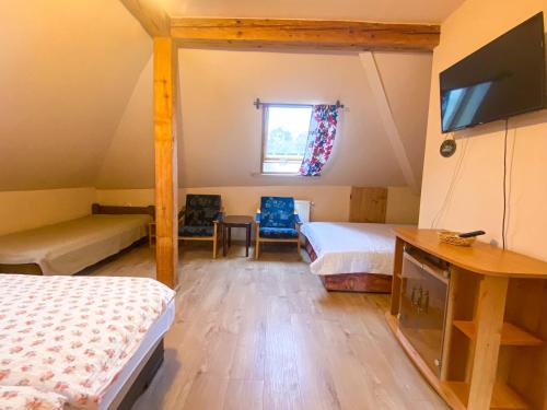 a attic bedroom with two beds and a window at István Vendégház in Eger