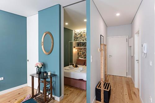 Pokój z niebieskimi ścianami i sypialnią z łóżkiem w obiekcie Turquoise Central Flat w AC & Balcony by LovelyStay w Porto