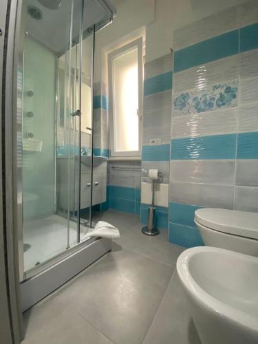 a bathroom with a shower and a toilet and a sink at Melody Rooms in Soverato Marina