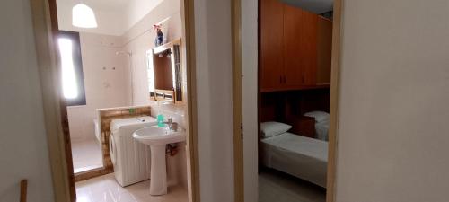 a small bathroom with a sink and a bed at La Rosa Dei Venti in Castellammare del Golfo