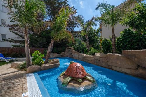 a pool in a backyard with a turtle in the water at Áncora Salou La Siesta Apartments in Salou
